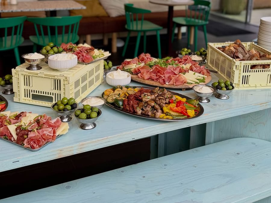 Buffet mit Antipasti, Aufschnitt, Oliven und Brot in Stapelkisten